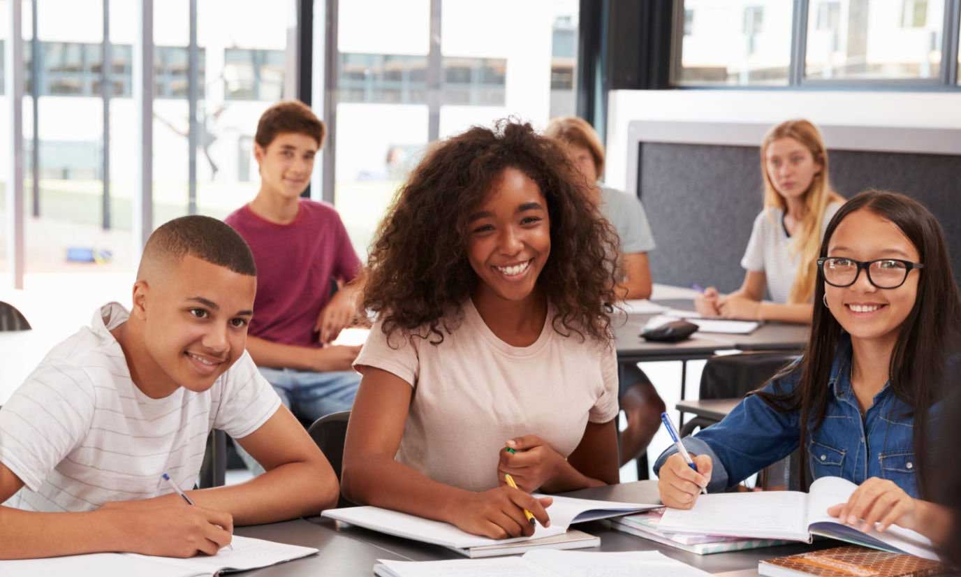A diverse group of middle school students working together in class.