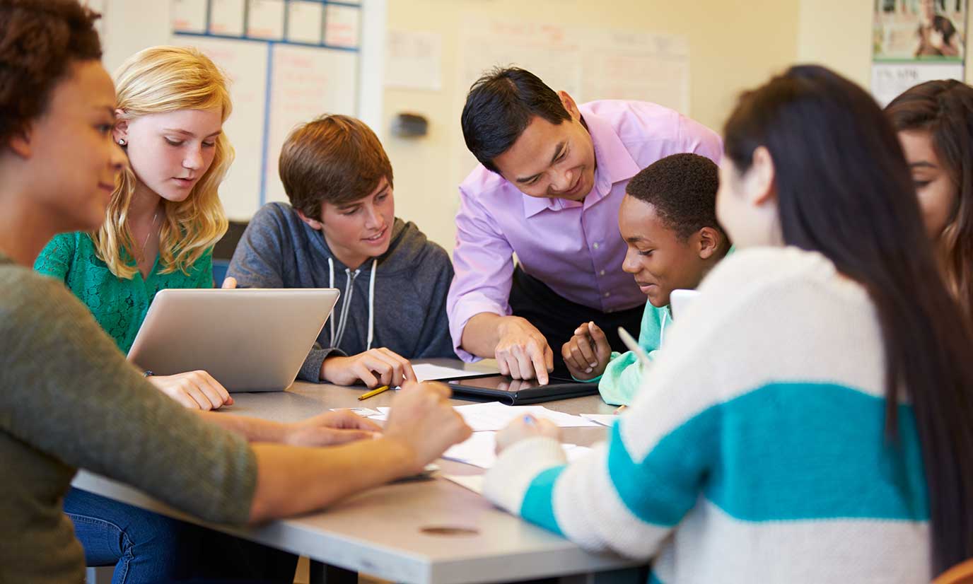Teacher working with a group of diverse students
